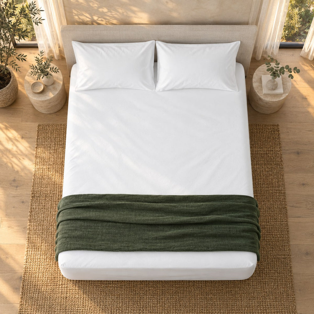 The Huxberry ActivGuard 5-Sided Mattress Protector from above with a green linen throw