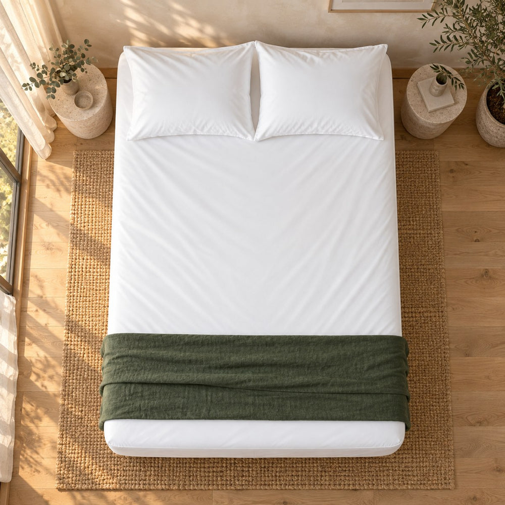 The Huxberry ActivChill 5-Sided Mattress Protector from above with a green linen throw