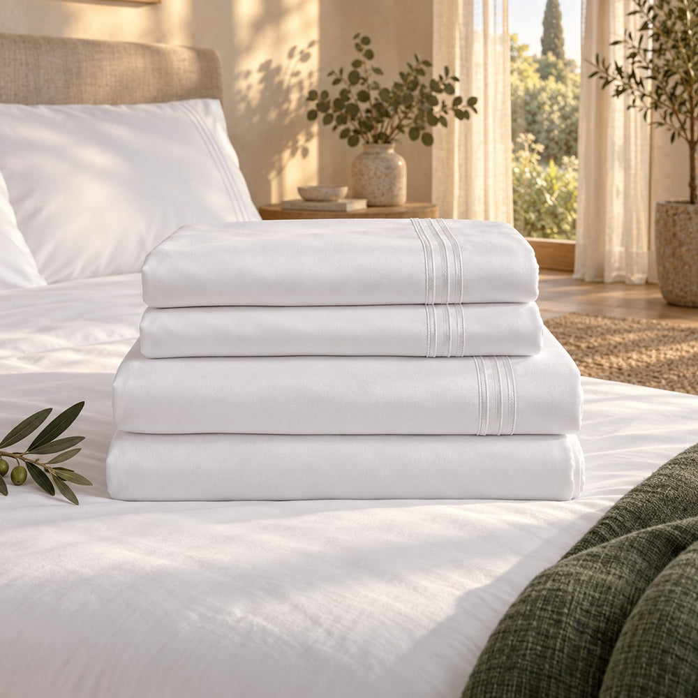 The Huxberry Essence Tencel Sheets Set neatly folded on a made bed