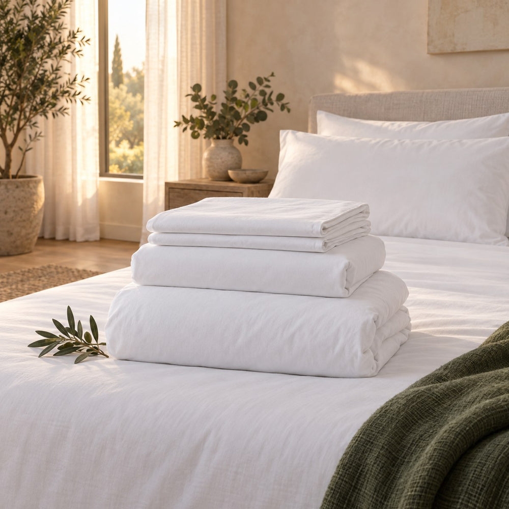 The Huxberry Organic Cotton Bedding Bundle neatly folded on a made bed