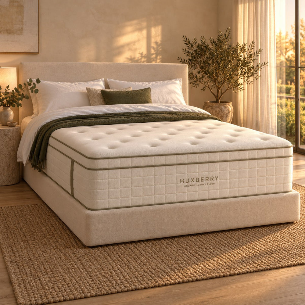 Huxberry Organic Luxury Plush Mattress on a made bed in a warm, light bedroom